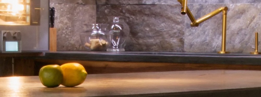Two mangoes sit on a kitchen counter.