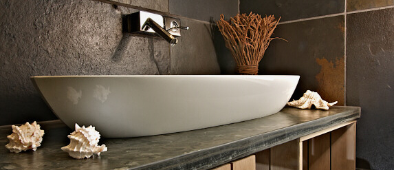 A white sink on a slate counter.