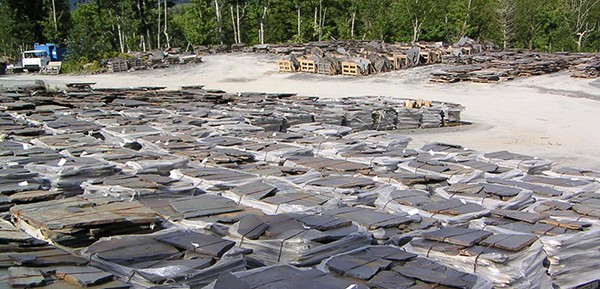 A large pile of high-quality slate products in a wooded area.