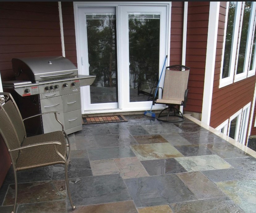 A patio with scotia stone and chairs.