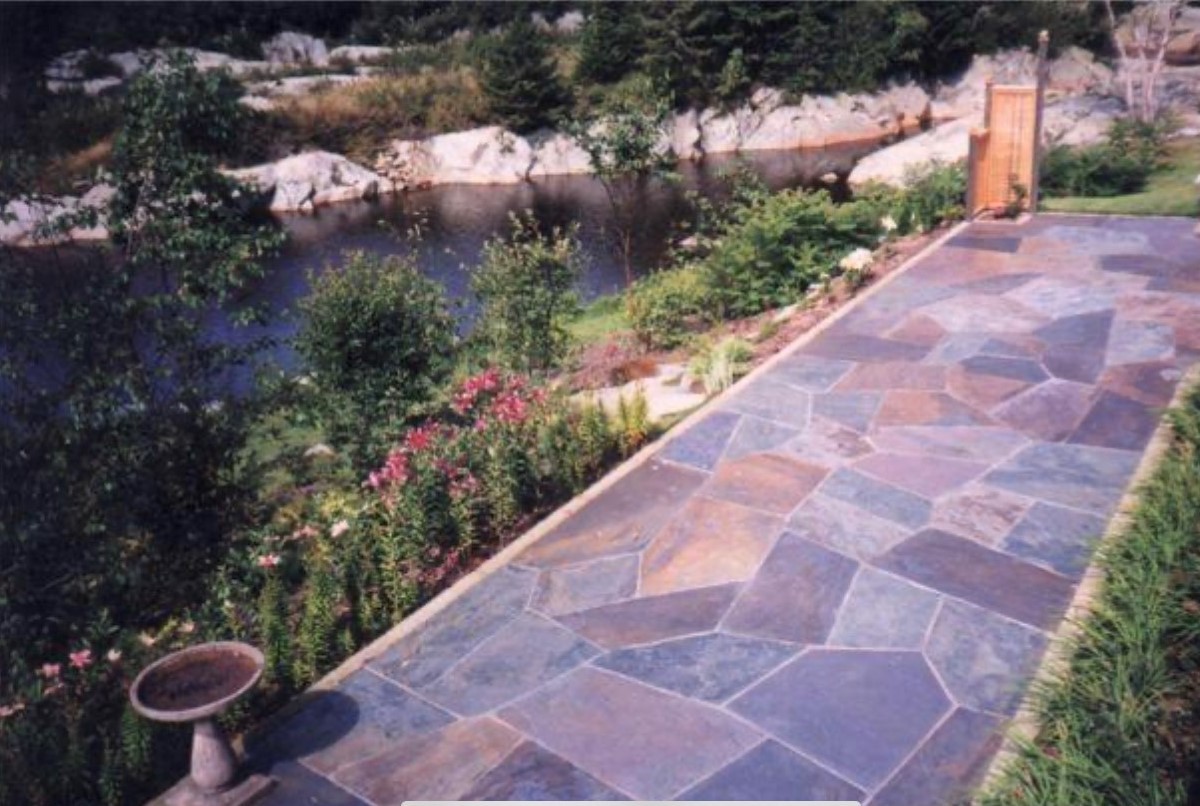 A blue scotia stone walkway with a river in the background.