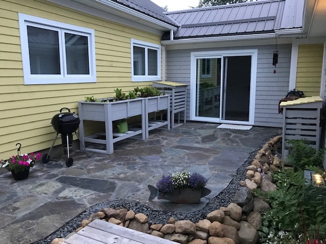 Backyard area with stone flooring and plants