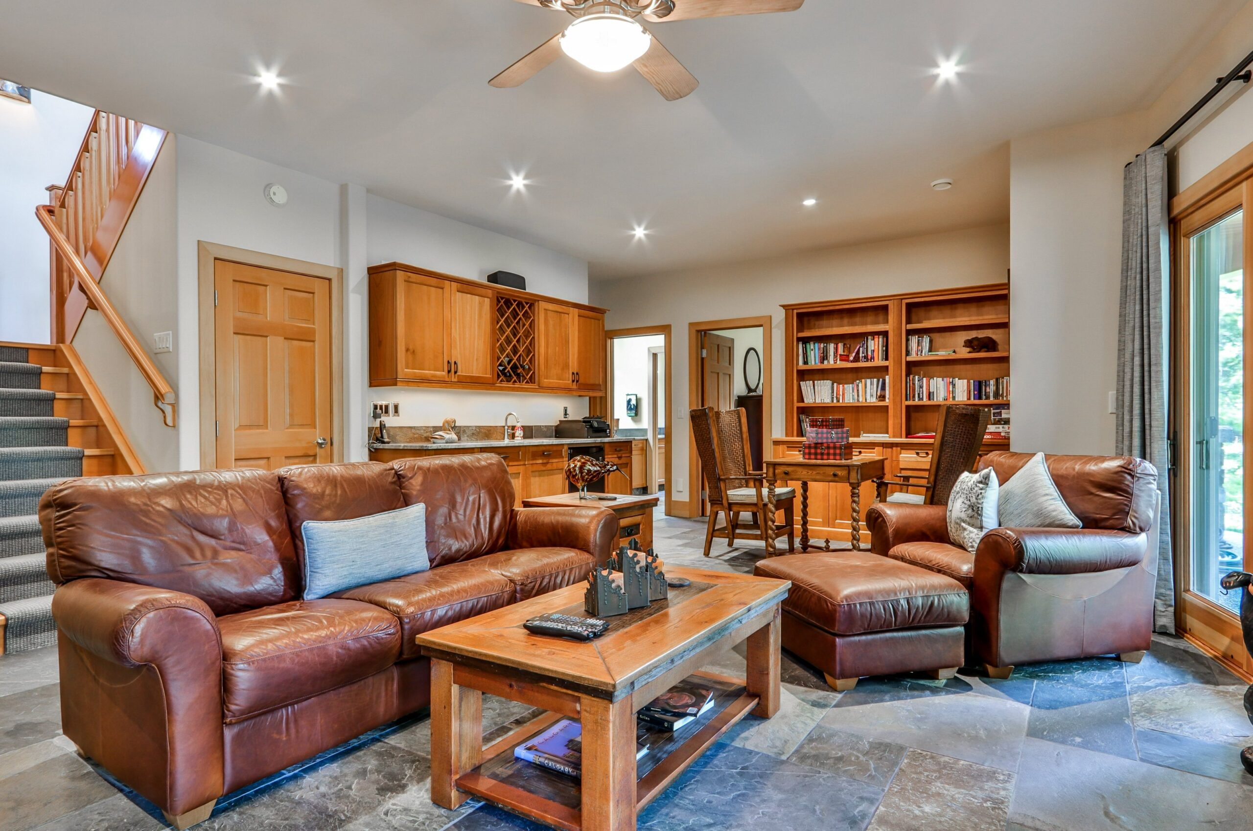 A family room with couches in the middle and book shelves in the back